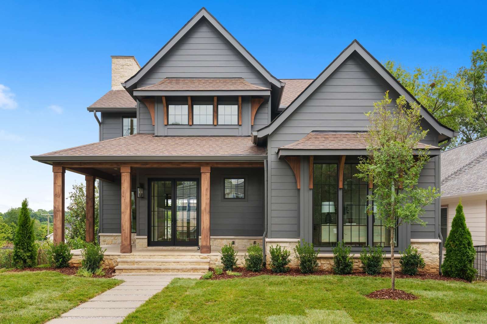 Gray Craftsman-style house with a covered front porch and landscaped yard