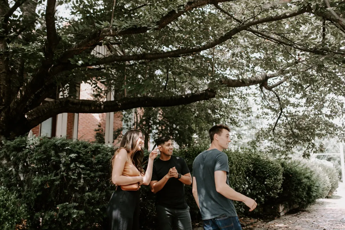 Matthew Marcus walking with two people along a tree-lined Nashville sidewalk